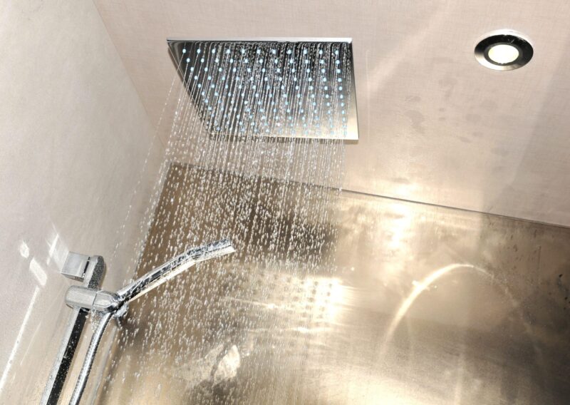 water falling from an overhead shower after a luxury plumbing upgrade