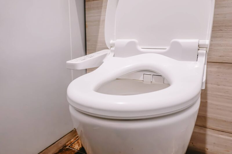 a white bidet toilet with the lid open