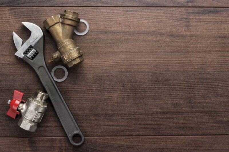 plumbing tools and equipment laying down on a wooden surface