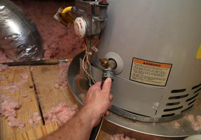 technician hand reaching out to repair a tanked water heater