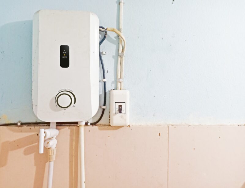 a tankless water heater system installed against a wall
