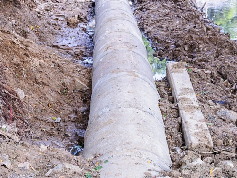 a sewer pipe system running across the muddy ground