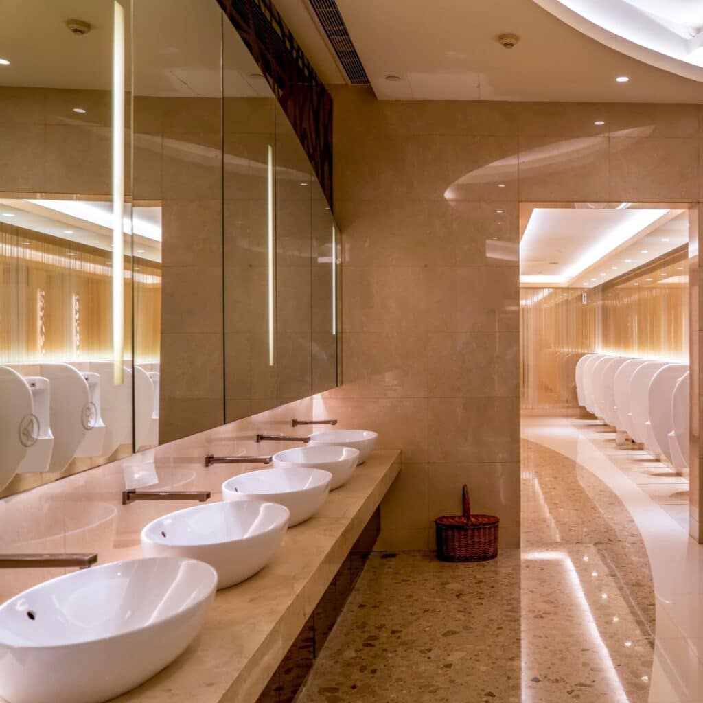 a row of bathroom sinks lined side by side in a commercial bathroom
