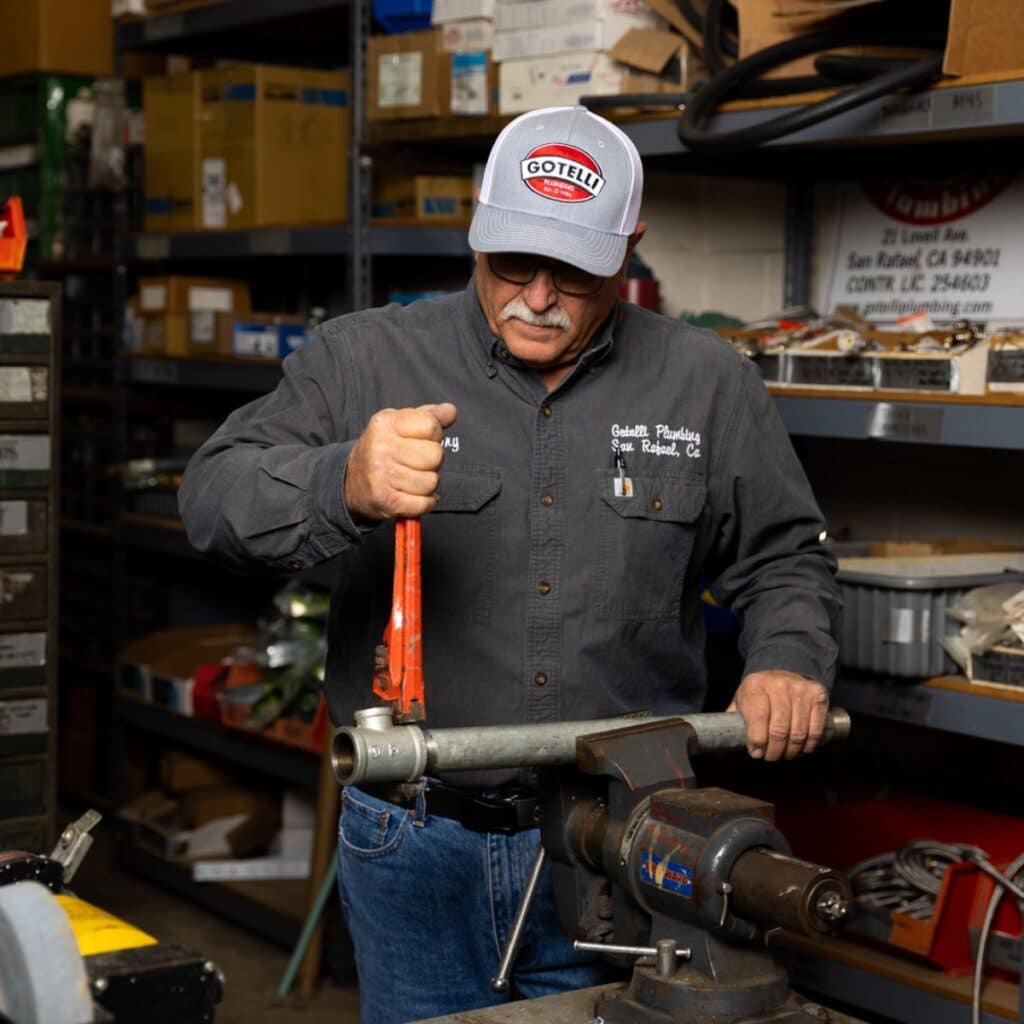 a Gotelli plumber using tools to make an adjustment to a backflow preventer