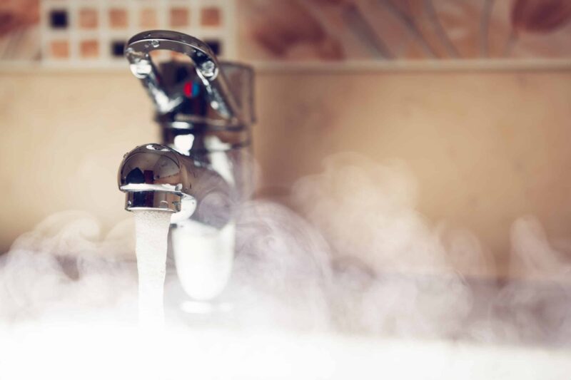 a bathroom sink with steam coming from the hot water